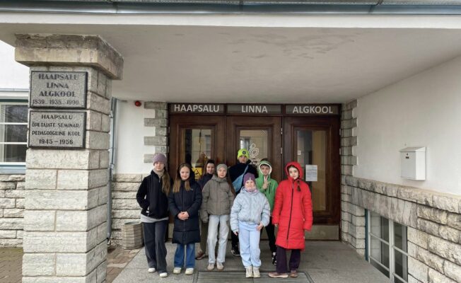 8 skolēni - Gļebs Lokotošs (4.a), Loreta Zablocka (4.b), Estere Bužinska (4.d), Letīcija Plinte (4.e), Kārlis Vaskāns (5.a), Linda Goldberga (5.b), Dārta Brēķe (5.c), Ance Valtere (5.e) pie skolas Igaunijā