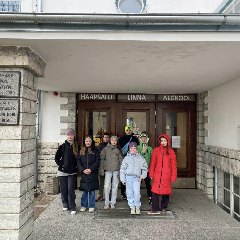 8 skolēni - Gļebs Lokotošs (4.a), Loreta Zablocka (4.b), Estere Bužinska (4.d), Letīcija Plinte (4.e), Kārlis Vaskāns (5.a), Linda Goldberga (5.b), Dārta Brēķe (5.c), Ance Valtere (5.e) pie skolas Igaunijā