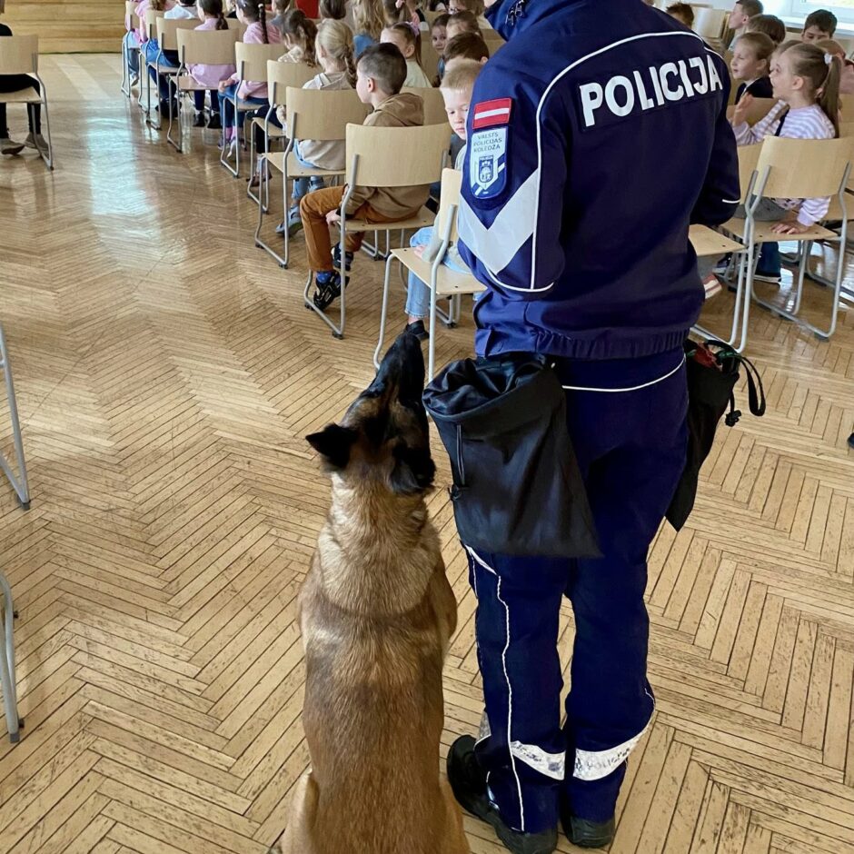 Attēlā redzams valsts policijas darbinieks ar dienesta suni