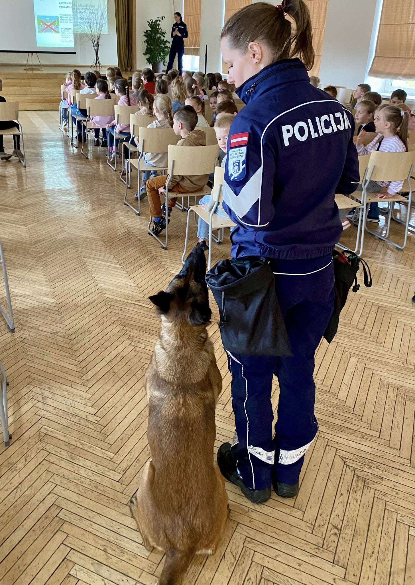 Attēlā redzams valsts policijas darbinieks ar dienesta suni