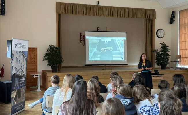 Lektore skolas Lielajā zālē vada skolēniem lekciju