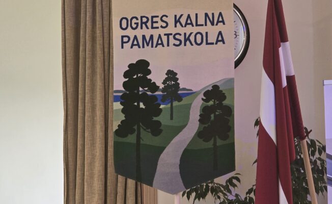 Skolas karogs blakus Latvijas karogam Lielajā zālē