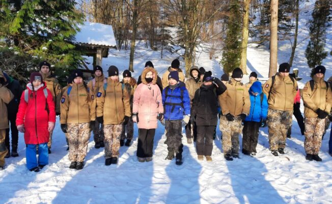 Jaunsargu kopbilde ziemas dienā kalna pakājē