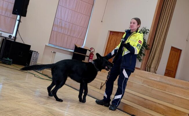 Valsts policijas kinoloģe ar dienesta suni skolas Lielajā zālē