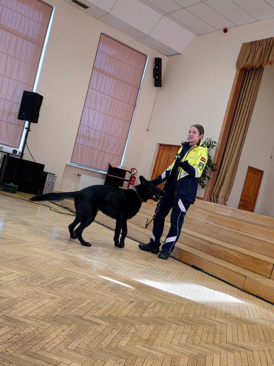 Valsts policijas kinoloģe ar dienesta suni skolas Lielajā zālē